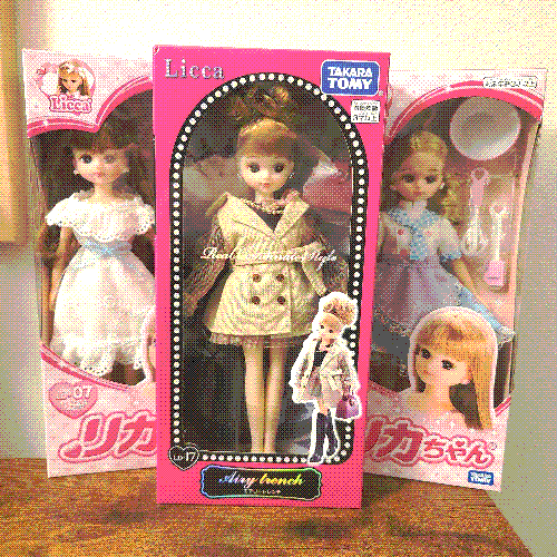 photograph of a shelf of 3 dolls in boxes