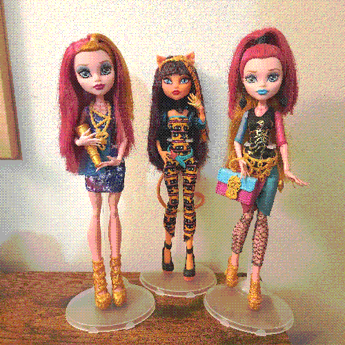 photograph of a shelf of three monster high dolls