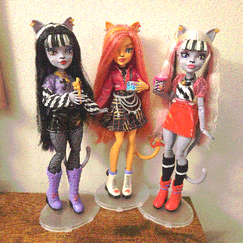 photograph of a shelf of three monster high dolls