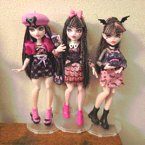 photograph of a shelf of three monster high dolls