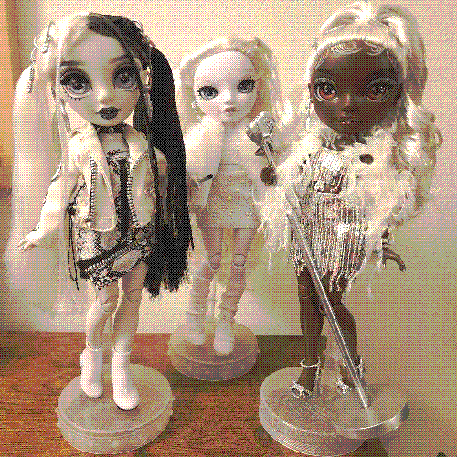 photograph of a shelf of three rainbow high dolls