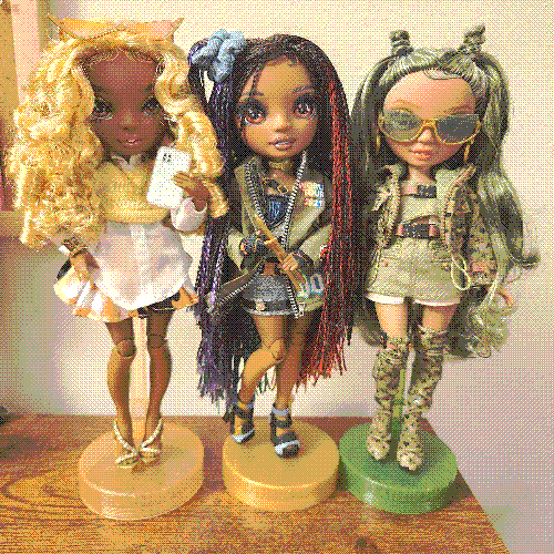 photograph of a shelf of three rainbow high dolls