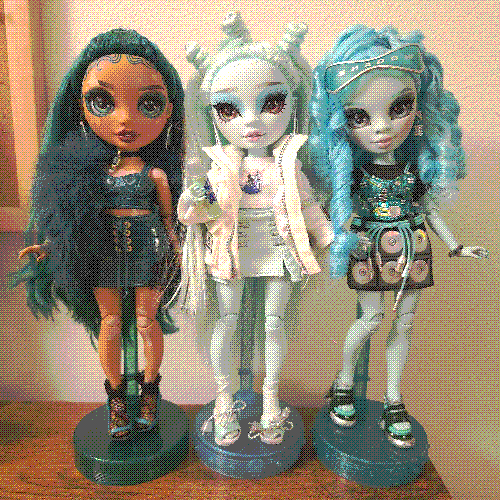 photograph of a shelf of three rainbow high dolls