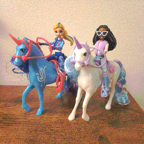 photograph of two mini human figures riding horses.